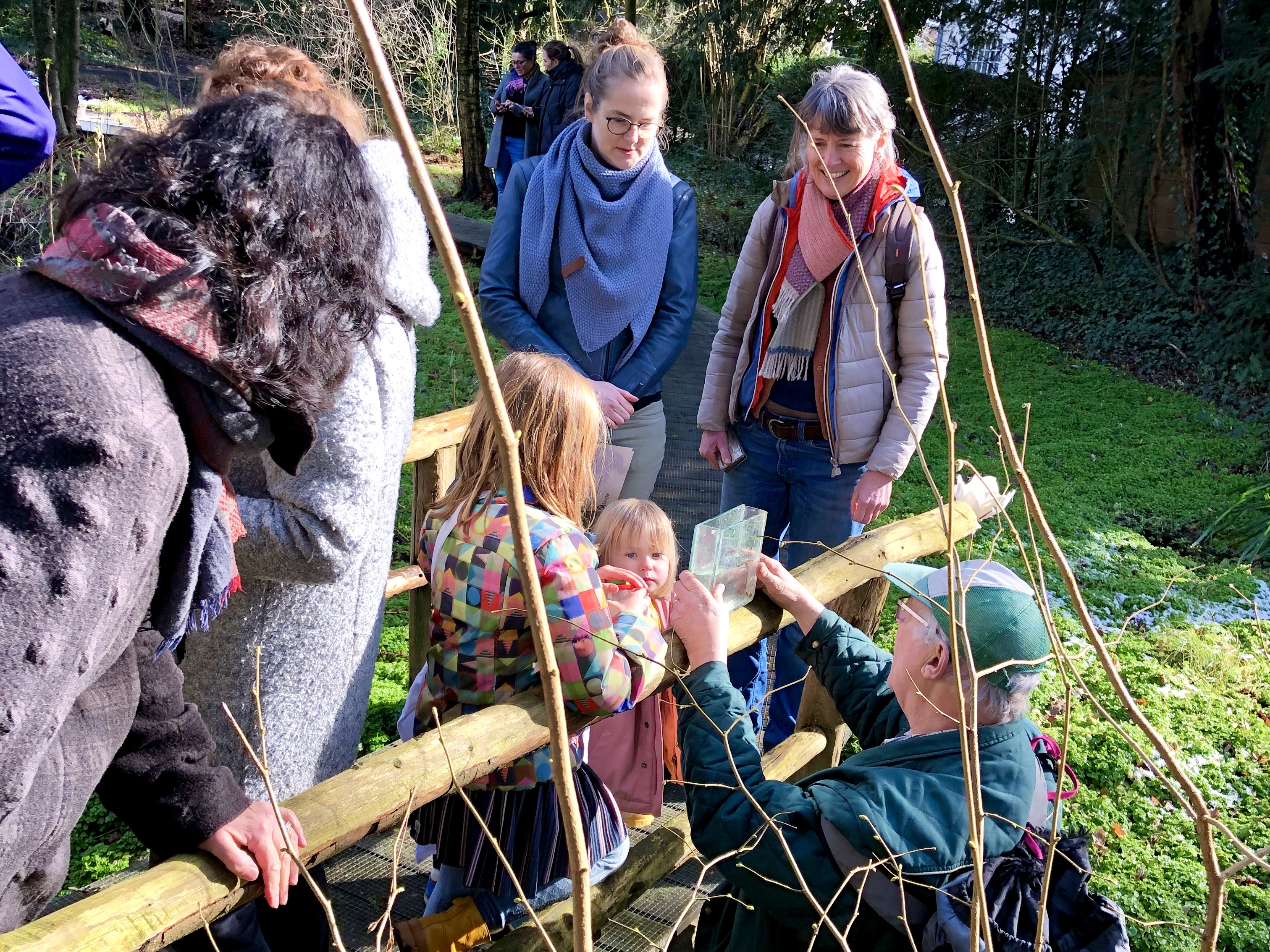 Groepje op stap in Heempark de Zomp: kleine kinderen kijken naar kleine waterdiertjes.